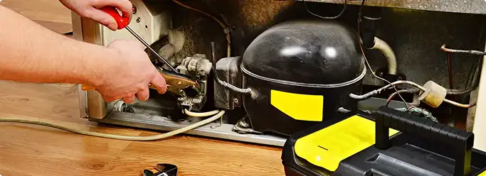Refrigerator repair technician fixing the compressor and wiring in Mount Pleasant, SC