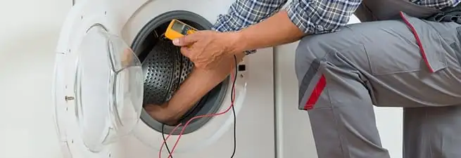 Dryer repair technician inspecting and repairing a clothes dryer in Charleston, SC