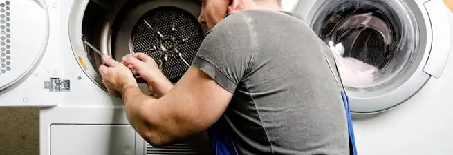 Dryer repair technician fixing a clothes dryer drum in Charleston, SC