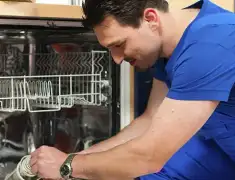 Dishwasher repair technician inspecting and servicing an open dishwasher in Charleston, SC