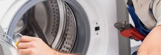 Appliance technician repairing a clothes dryer drum and internal parts in Charleston, SC