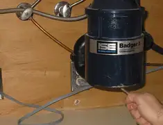 Garbage disposal repair technician tightening the mounting ring under a sink in Charleston, SC