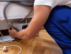 Appliance repair technician fixing refrigerator water line and connections in Charleston, SC