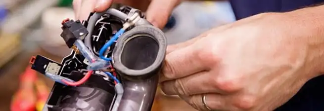 Vacuum repair technician reconnecting wiring and components in Charleston, SC