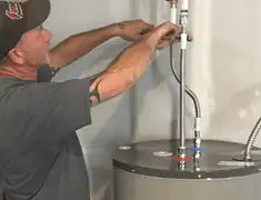 Water heater repair technician tightening supply line connections in Charleston, SC